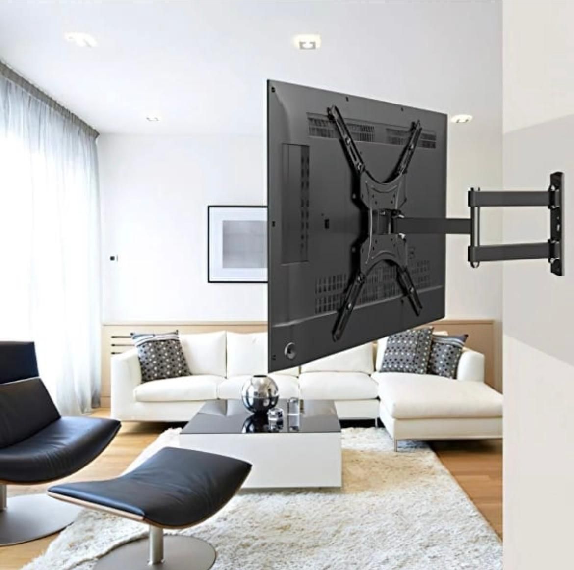 Soporte de pared para TV negro con herrajes y una caja que muestra el soporte instalado.