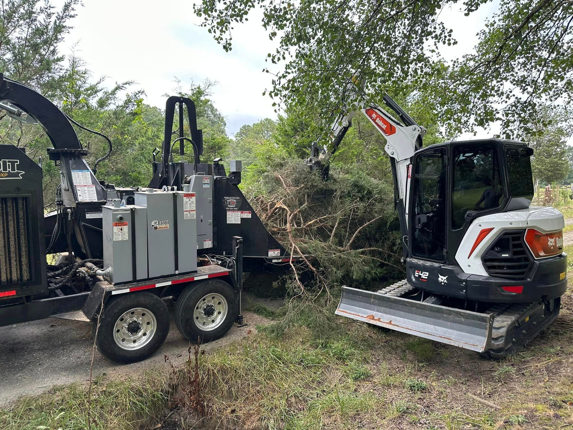 A bulldozer and a wood chipper are parked next to each other.