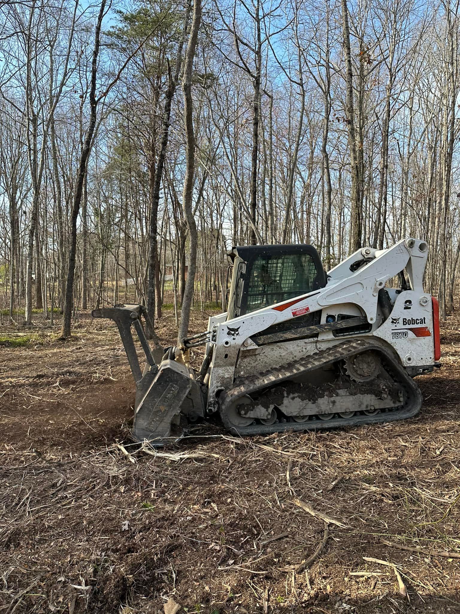 A bulldozer is sitting in the middle of a forest.