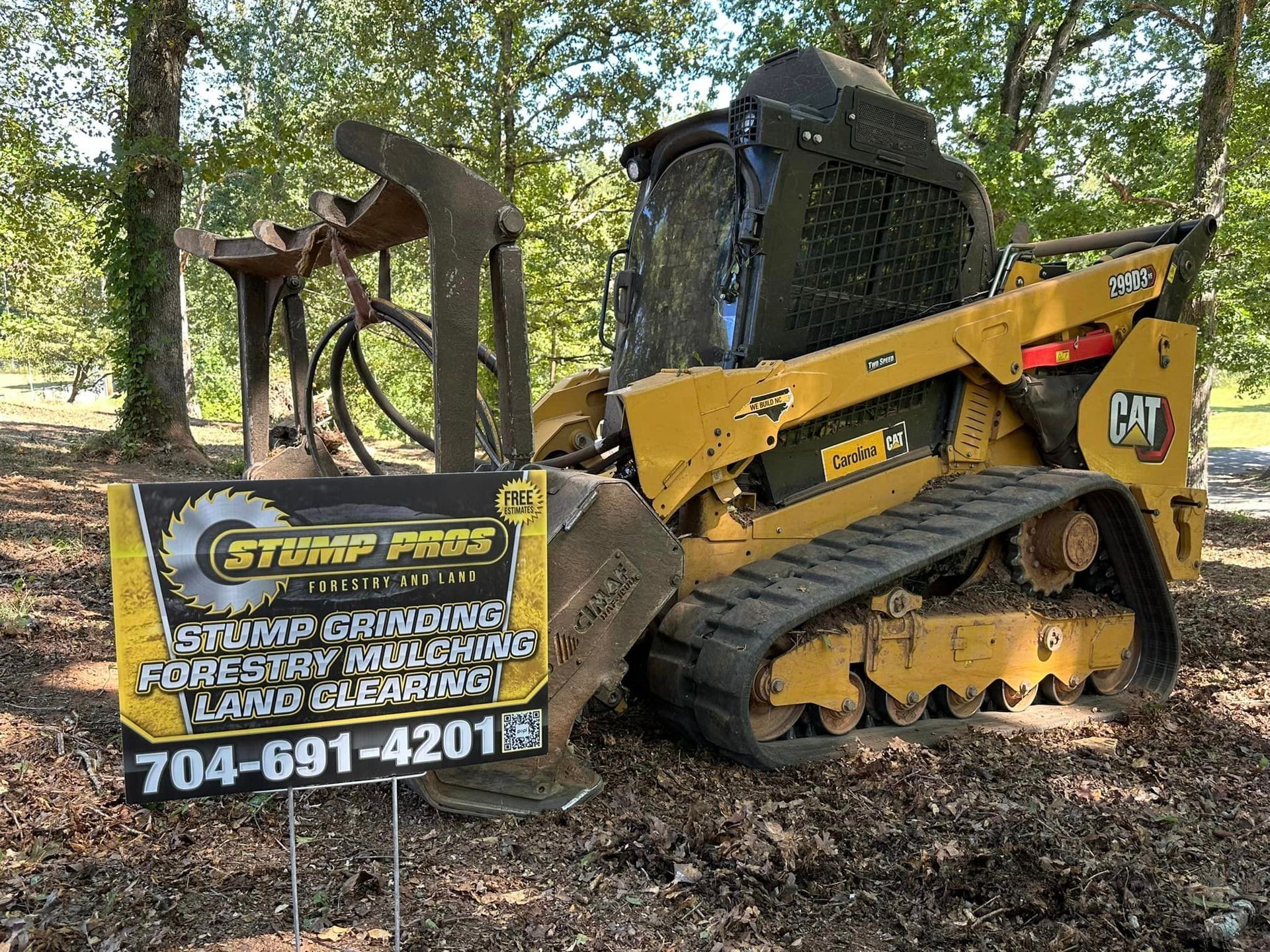 A bulldozer is parked in a field next to a sign.