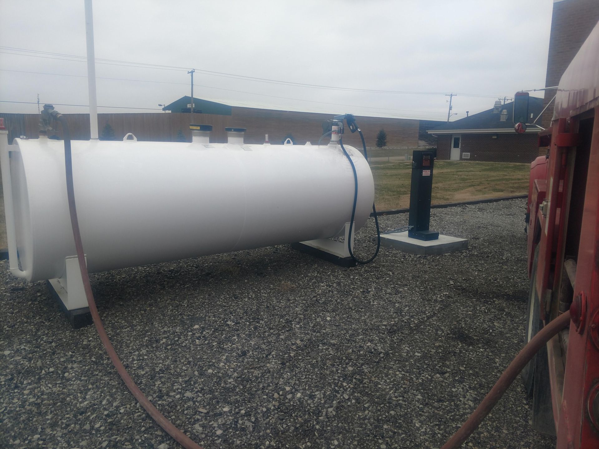Two fuel tanks are connected to a truck in front of a building