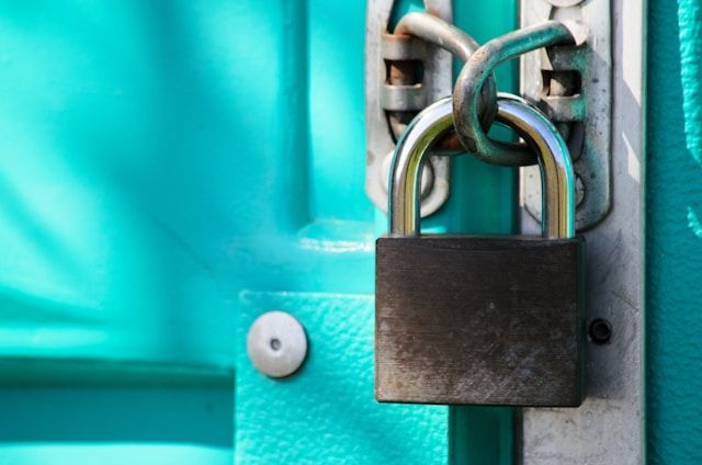 A turquoise door is enclosed via a lock.