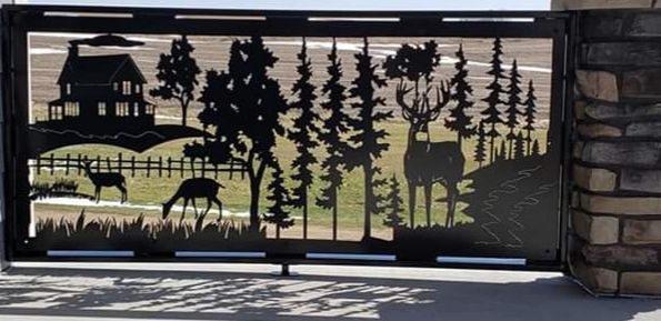 Metal gate with cut-out landscape scene featuring a house, deer, and trees.