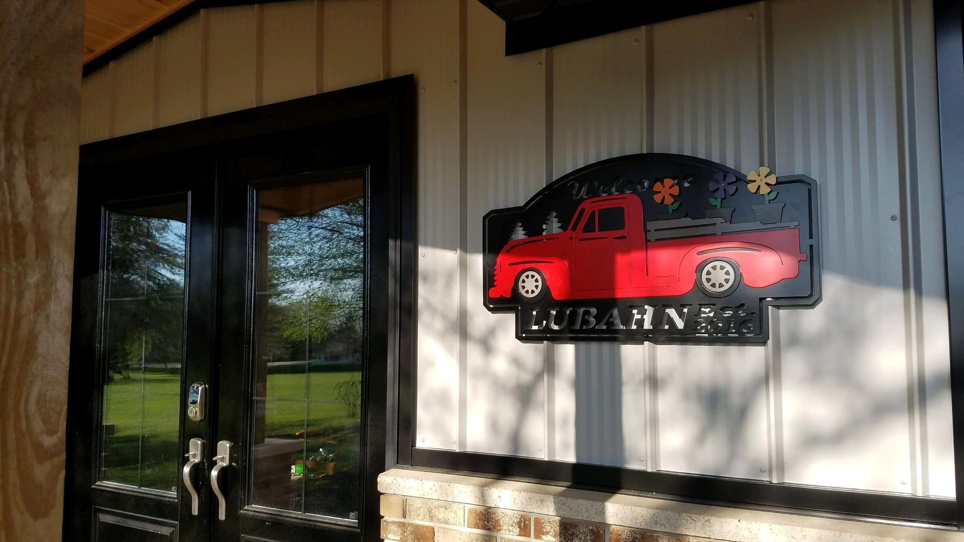 Red truck sign on a white building with black doors; 