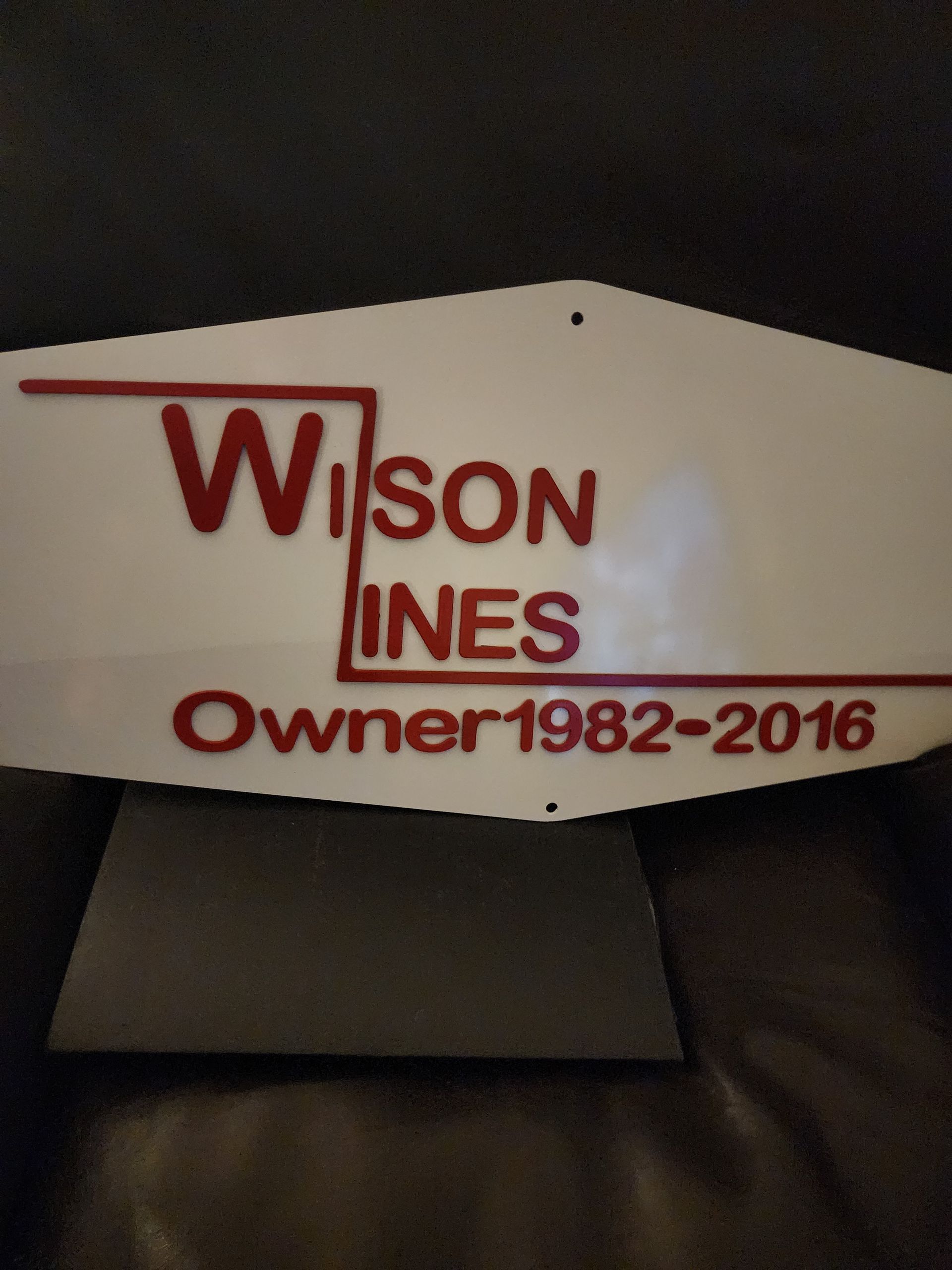 White sign with red text: 