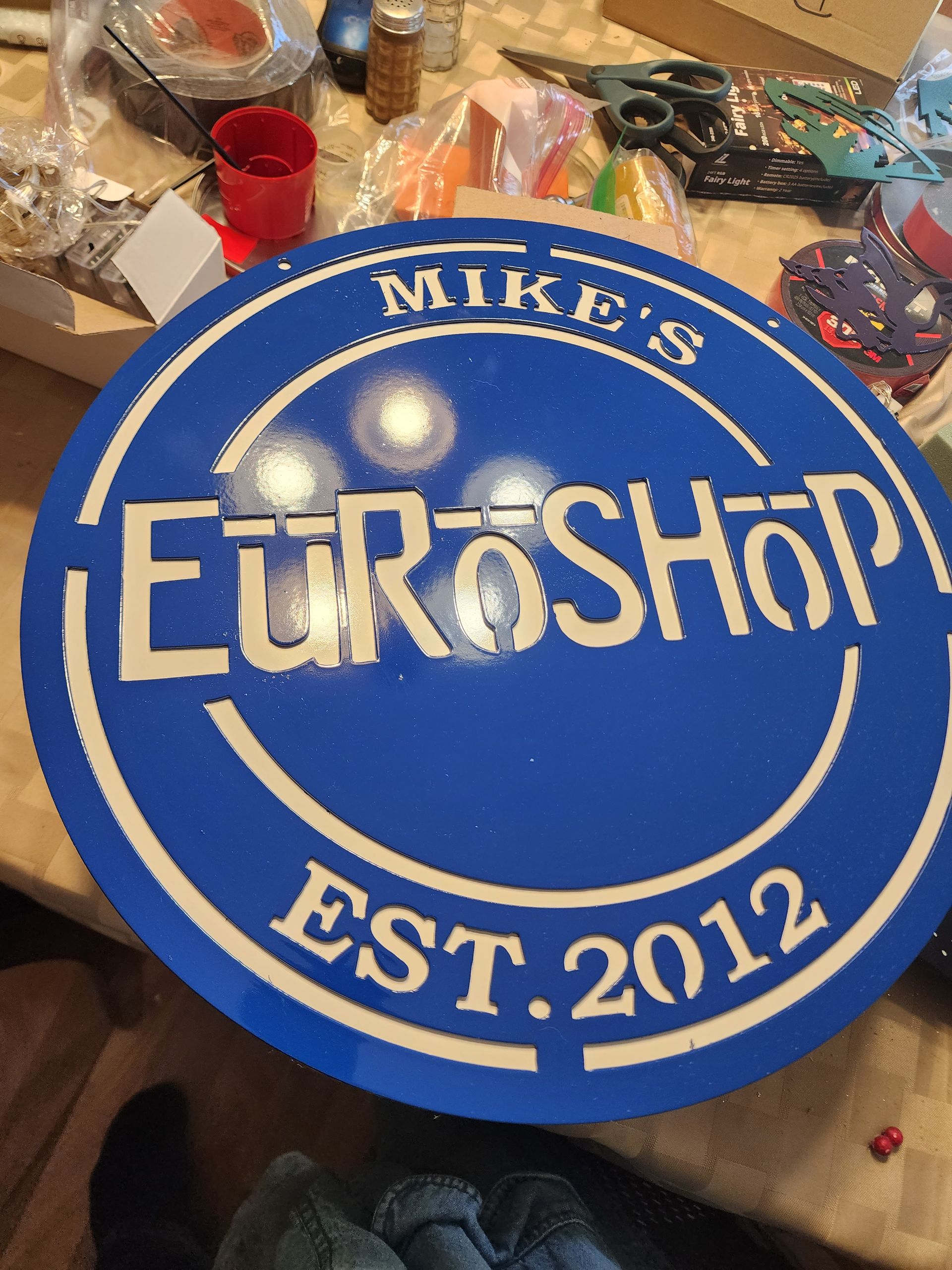 Blue round sign with white lettering. Reads 