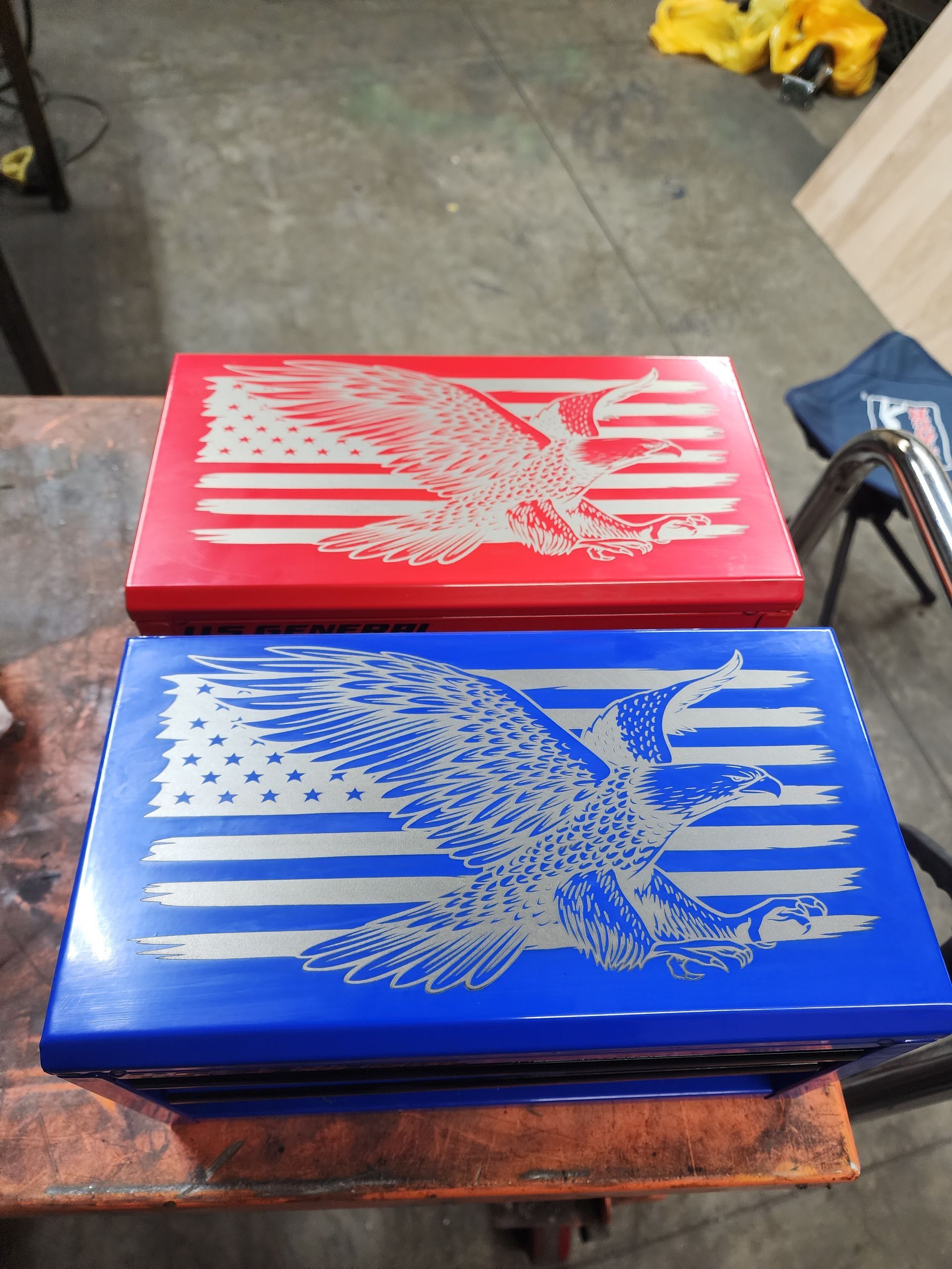 Two toolboxes, one red, one blue, with engraved eagle and American flag designs.