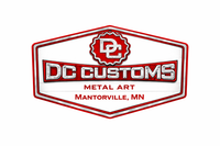 DC Customs logo, a stylized emblem with text and decorative elements, set against a wood grain background.