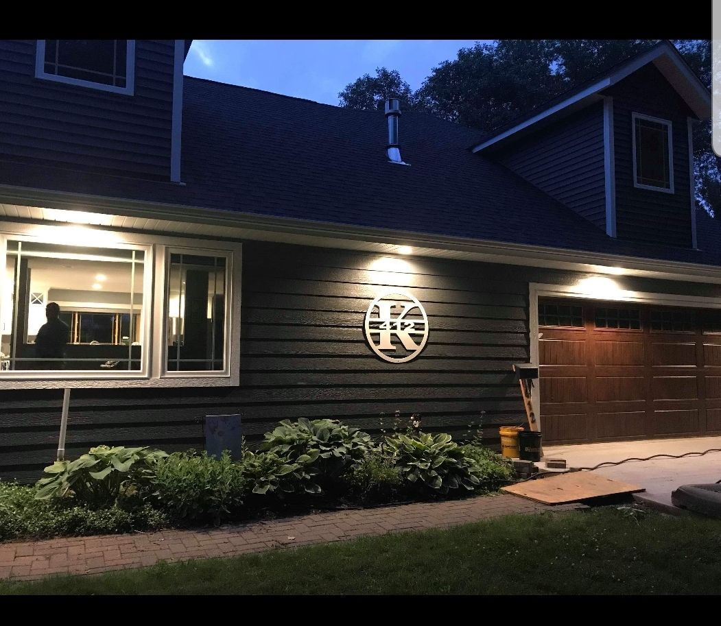 House exterior at dusk, illuminated by outdoor lights; a large 