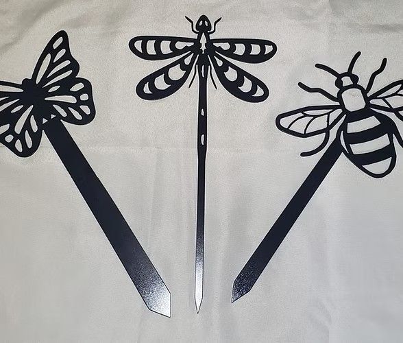Three metal garden stakes: butterfly, dragonfly, and bee, all black against a white background.