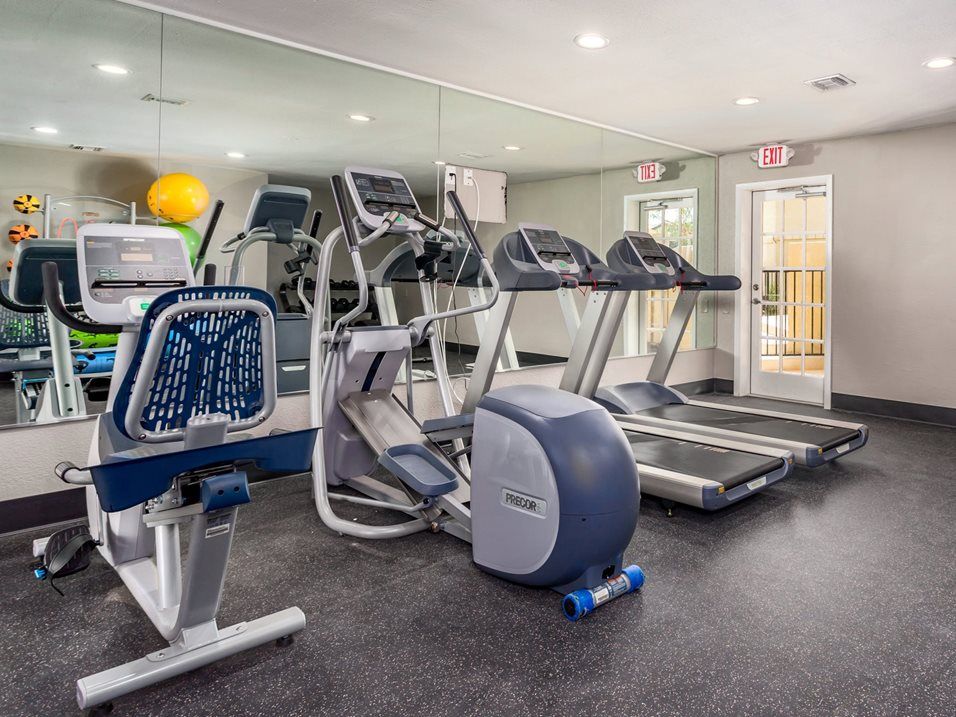 Gym with various exercise machines, including treadmills and elliptical.