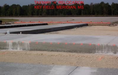 Taxiway relocation under construction at Key Field, Meridian, MS. Concrete blocks with orange markers sit in a dirt setting.