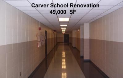 Long hallway in Carver School, renovated, with tan and white walls, and glossy floor.