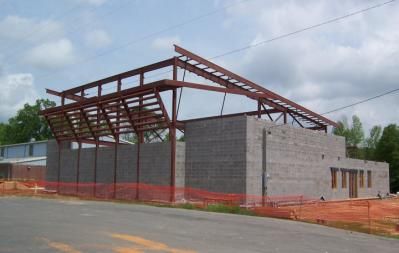 Building under construction with exposed steel beams and cinder block walls.