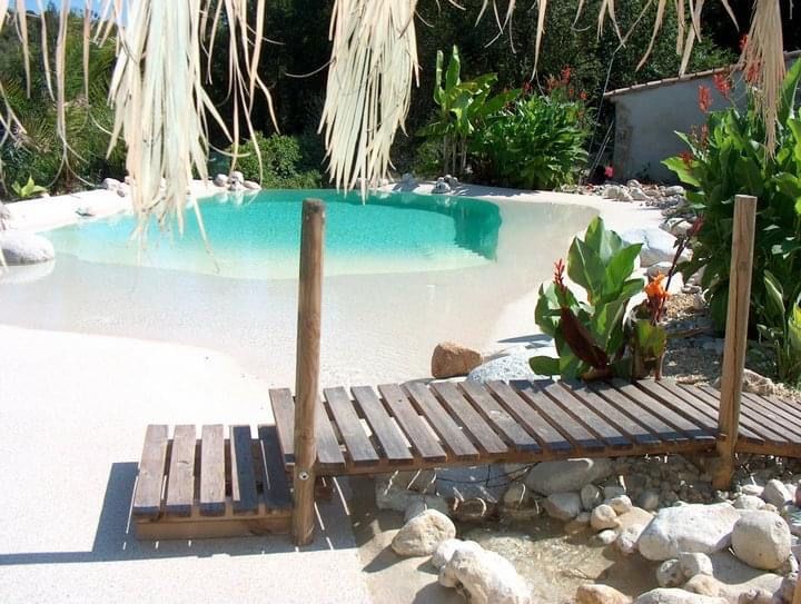 Un petit pont en bois menant à une piscine