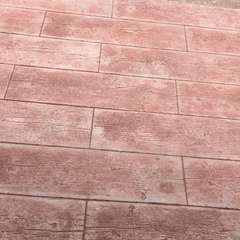 Pinkish textured concrete pavement with rectangular tile pattern and visible seams