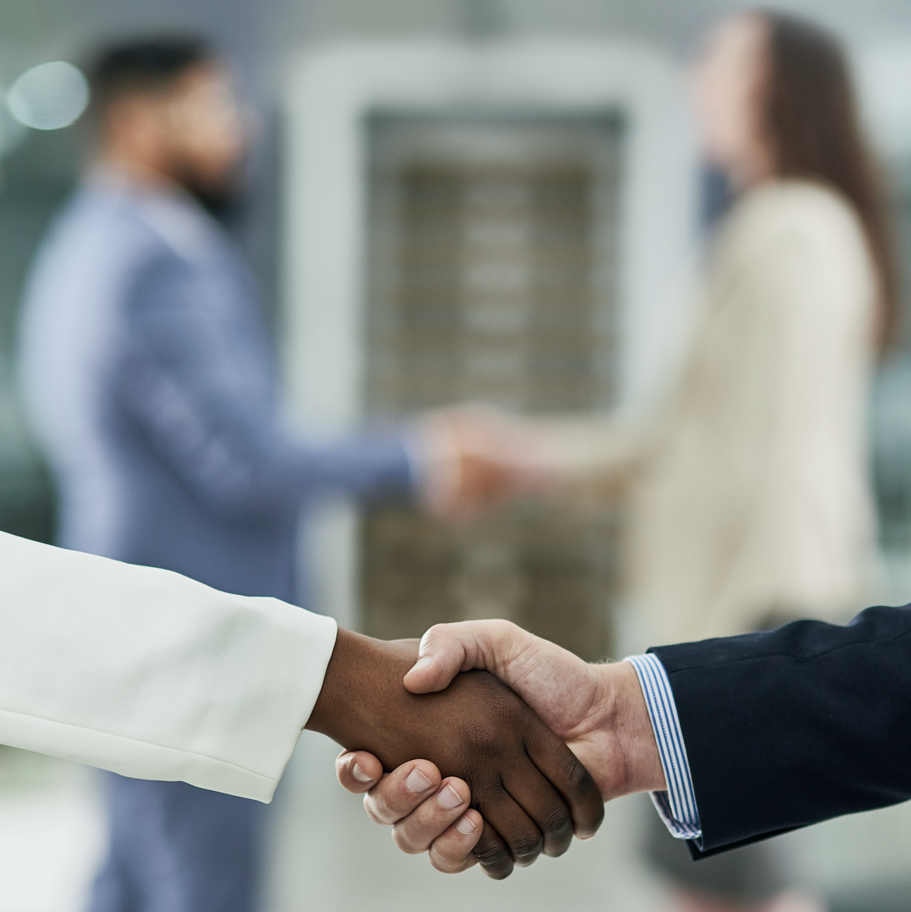 People are shaking hands making a business deal.