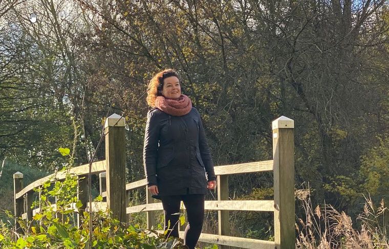 Jolijn loopt over een brug tijdens een wandelcoachsessie
