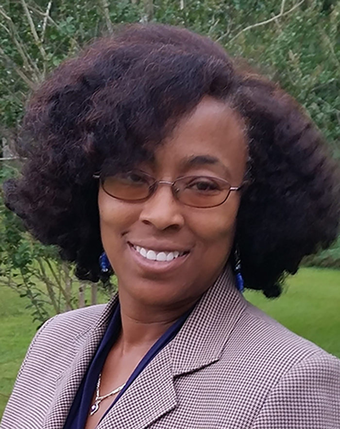 Attorney Kathy Richardson wearing glasses and a plaid jacket smiles for the camera