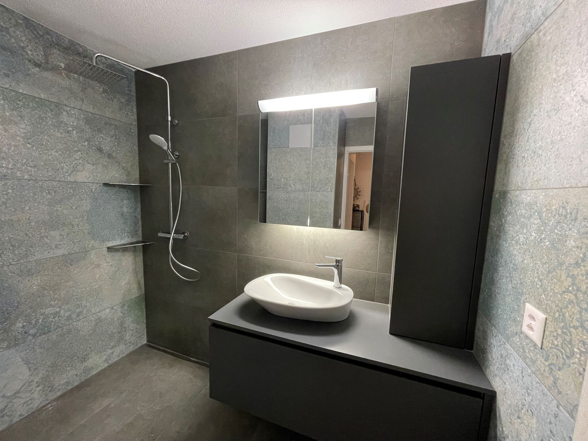 Ein Badezimmer mit Waschbecken, Spiegel und Dusche.