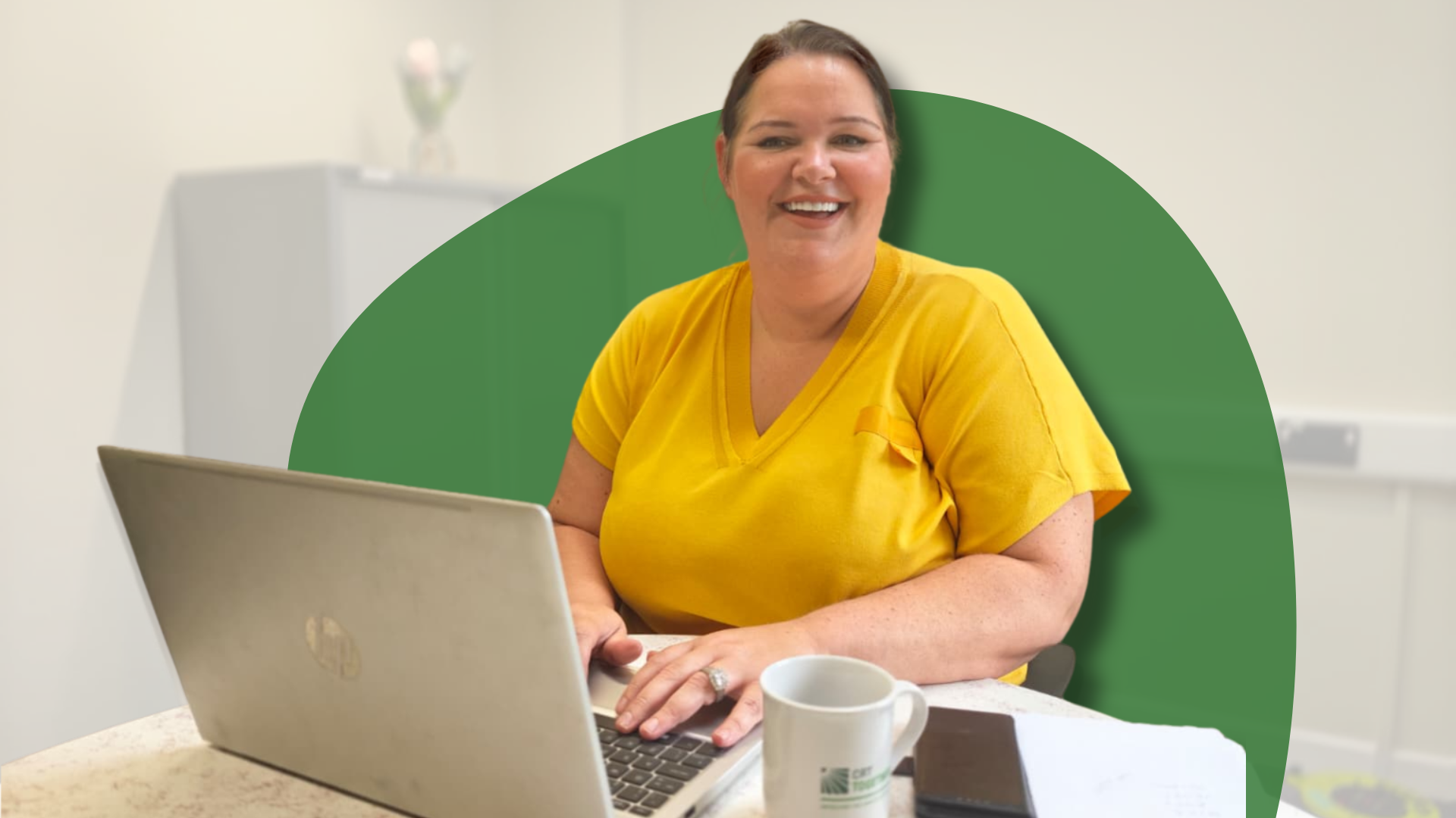 A close up of a woman smiling in front of a green background.
