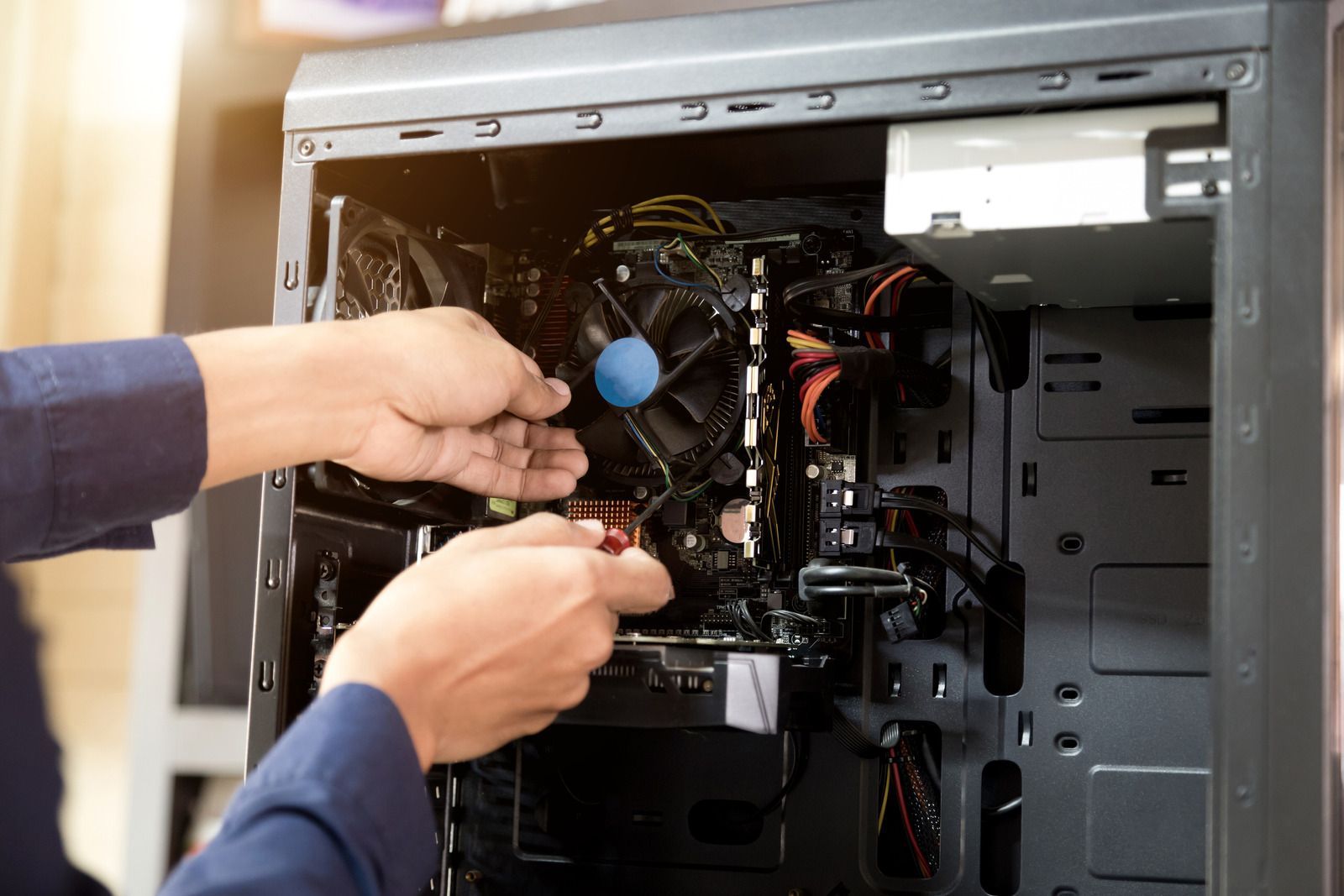 Hands installing a computer component inside an open desktop PC case