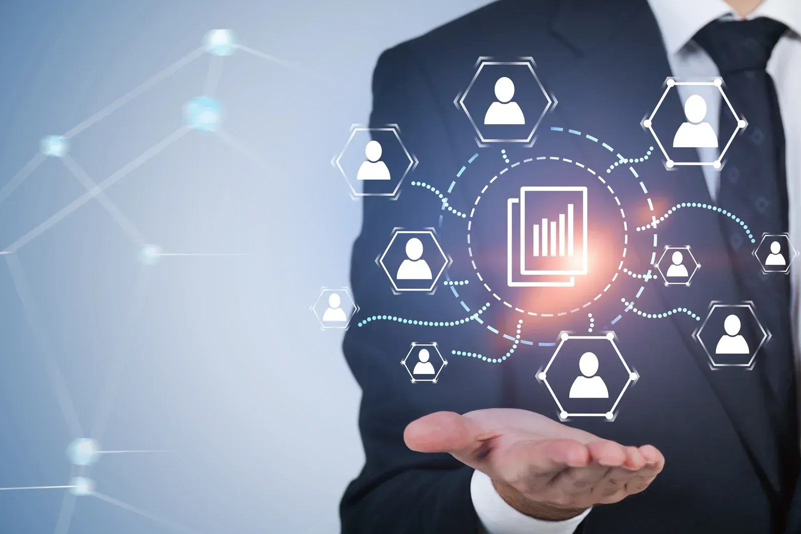 Businessperson in dark suit presenting glowing digital network icons and analytics chart