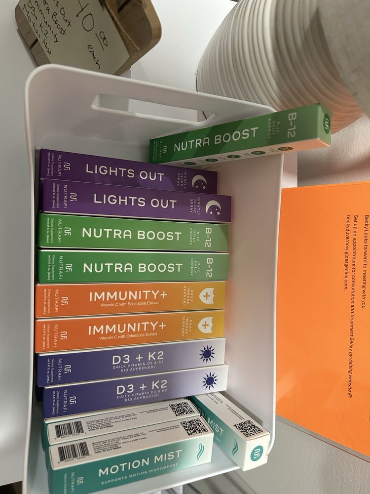 Assorted supplement boxes stacked on a shelf beside an orange folder and bowls in a bright store display