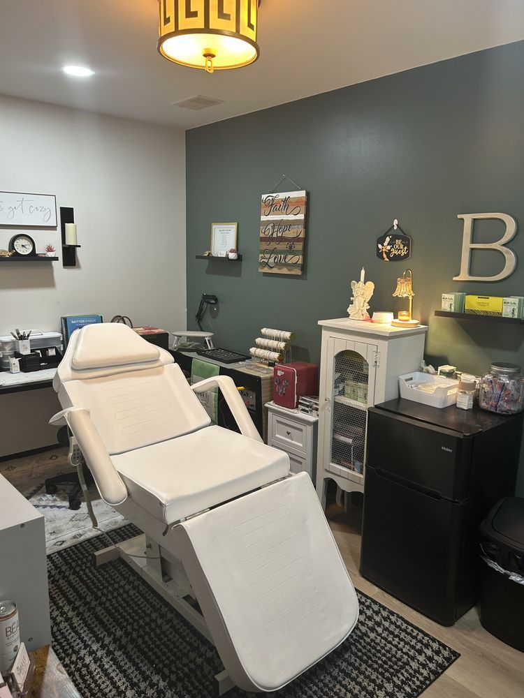 Empty massage chair in a teal treatment room with cabinets, decor, and a rug