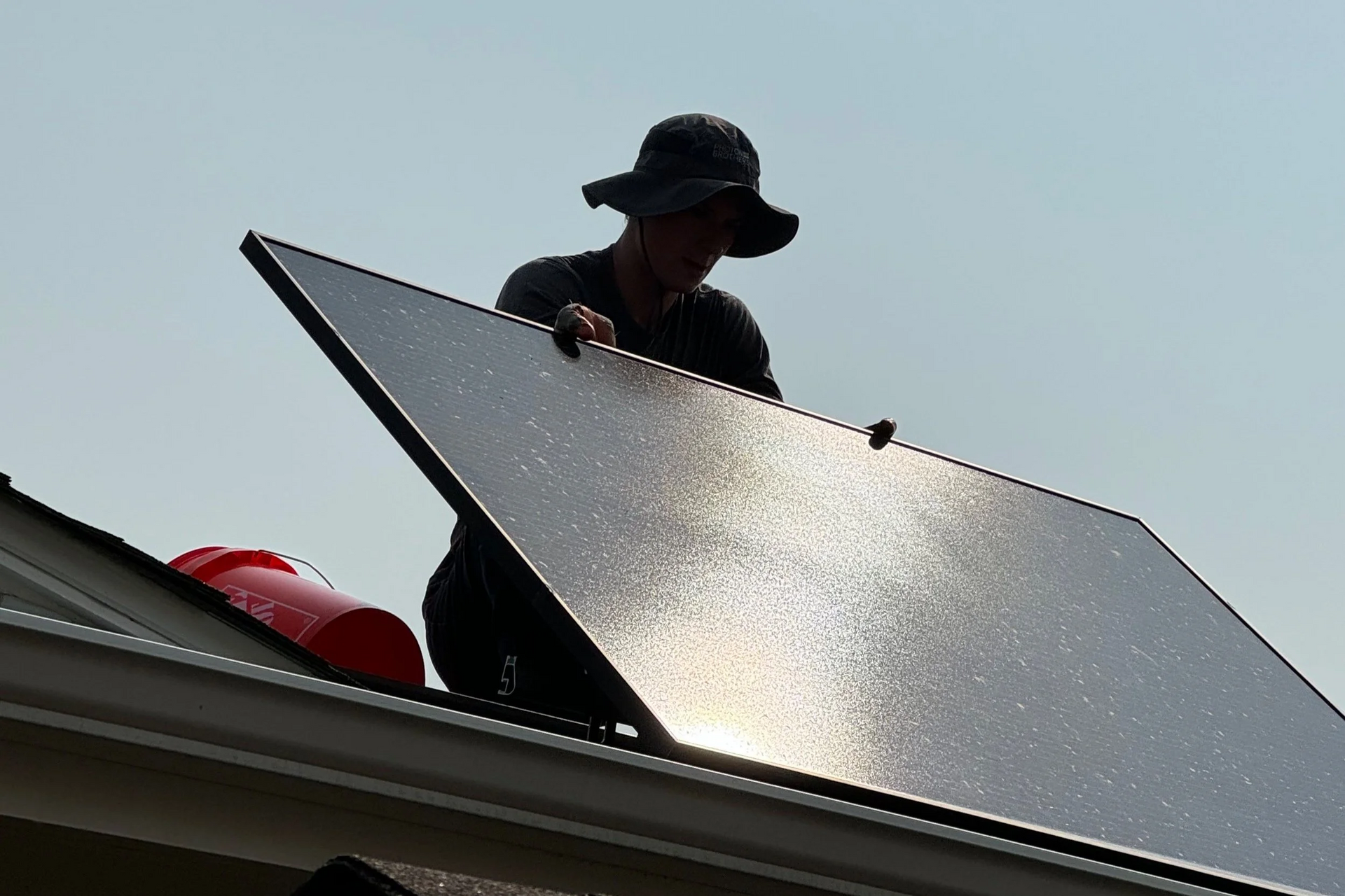 Solar panels reflecting the sunset. Mountain range in the background.
