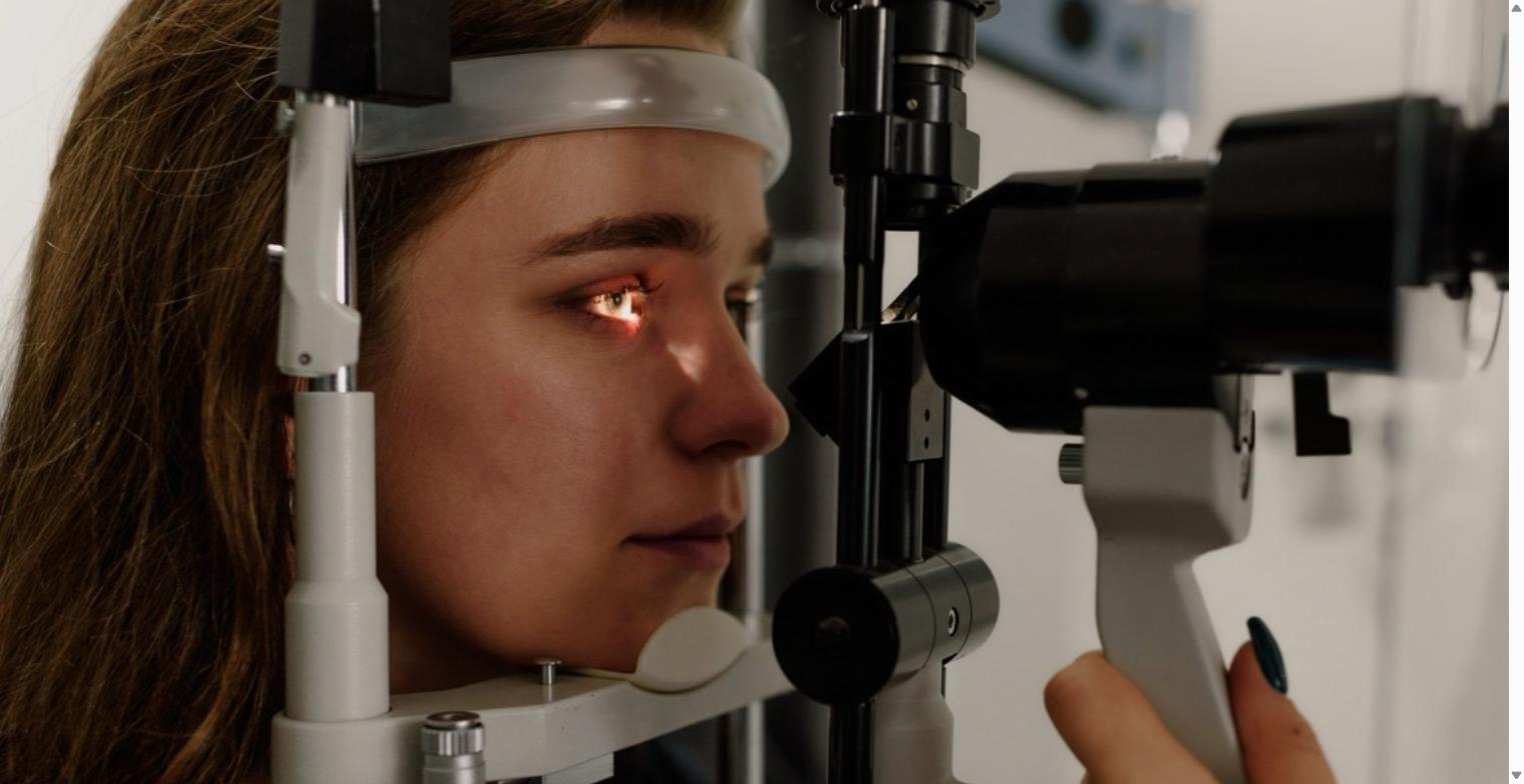 Woman receiving a comprehensive eye exam at an optometrist using a slit lamp device