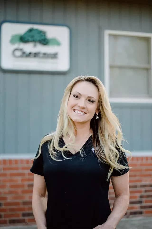 a woman in a black shirt is standing in front of a building .