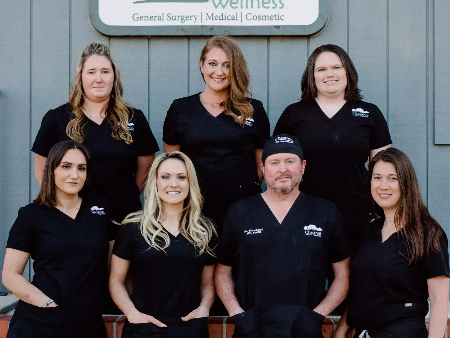 a group of people posing in front of a sign that says wellness