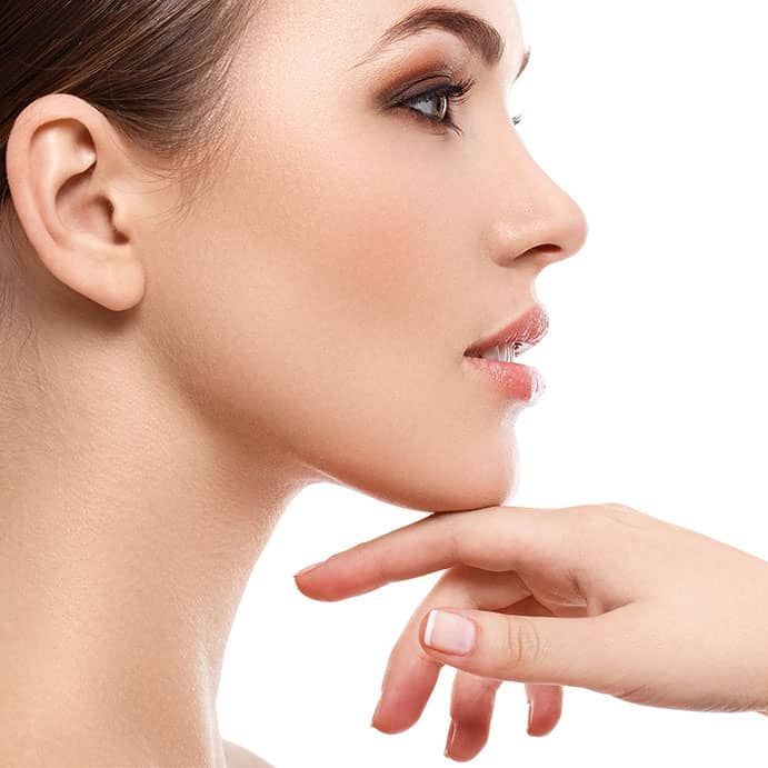 a close up of a woman 's face with her hand on her chin