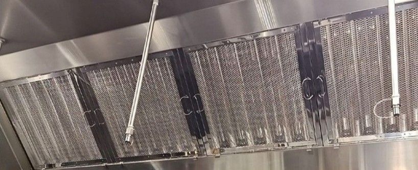 Perforated metal surface, possibly a grill, with diagonal lines of residue.
