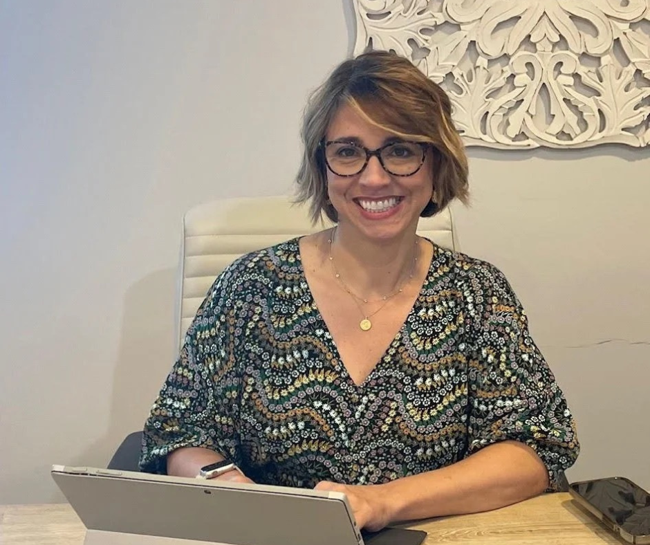 Healthcare provider smiling at desk with tablet, reviewing notes for weight management consult