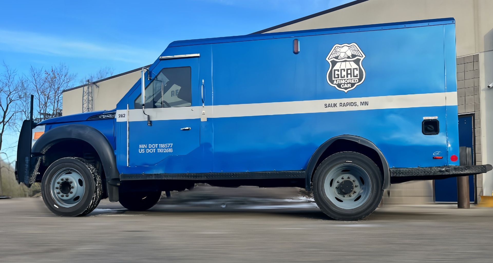 A blue and white van is parked on the side of the road