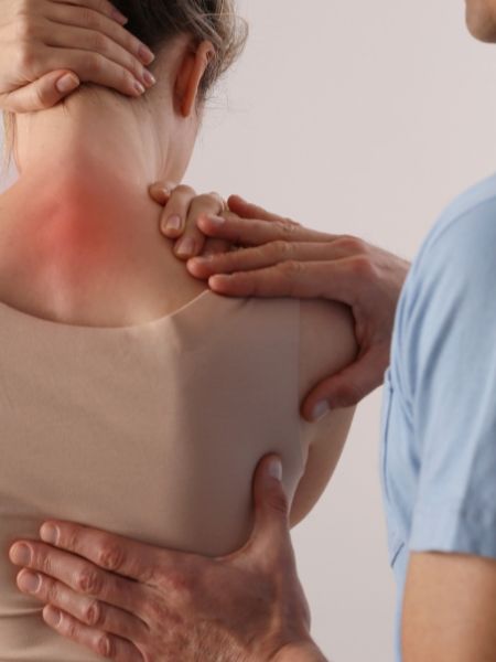 A woman getting pain management treatment from a chiropractor in Santa Rosa Beach, Florida.
