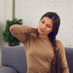 a woman is sitting on a couch with a Pinched Nerve