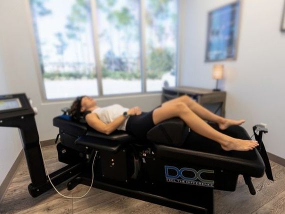 This is what a spinal decompression treatment looks like. A patient relaxes on a DOC spinal decompression table while gentle traction helps reduce pressure on the spine and supports natural healing