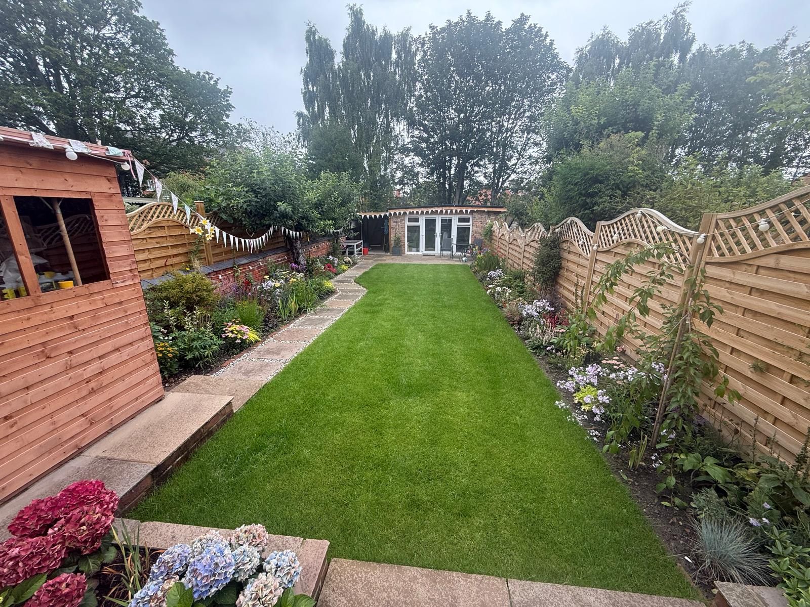 Person in blue gloves tending a molehill in a green lawn.