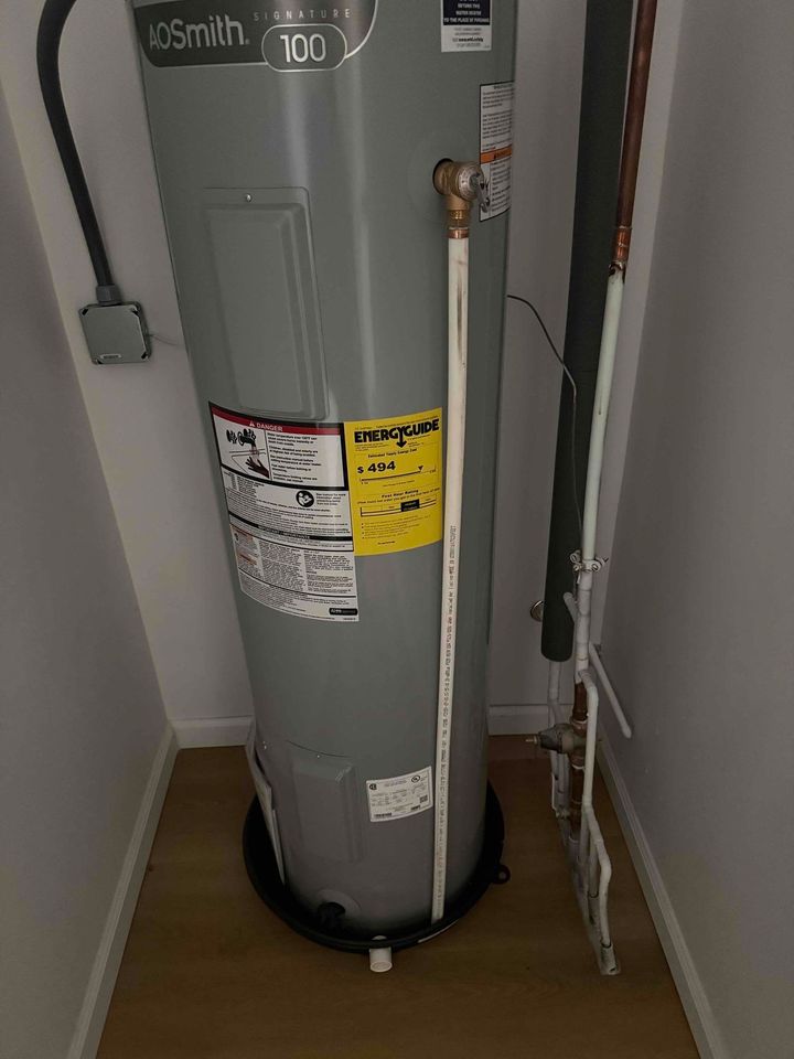 Technician removing old water heater for replacement