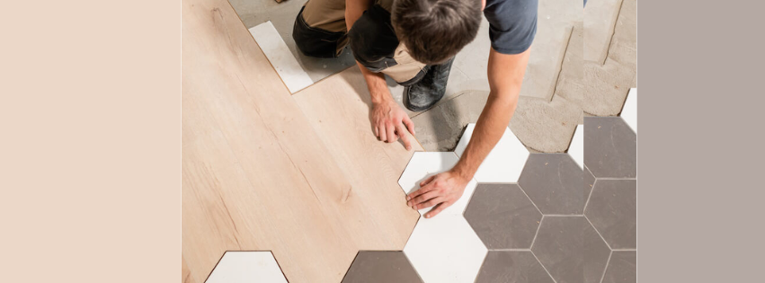 A man is installing a wooden floor and hexagonal tiles.