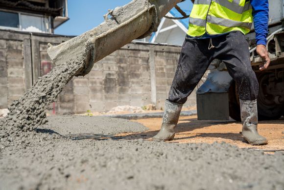 construction worker pouring wet concret road