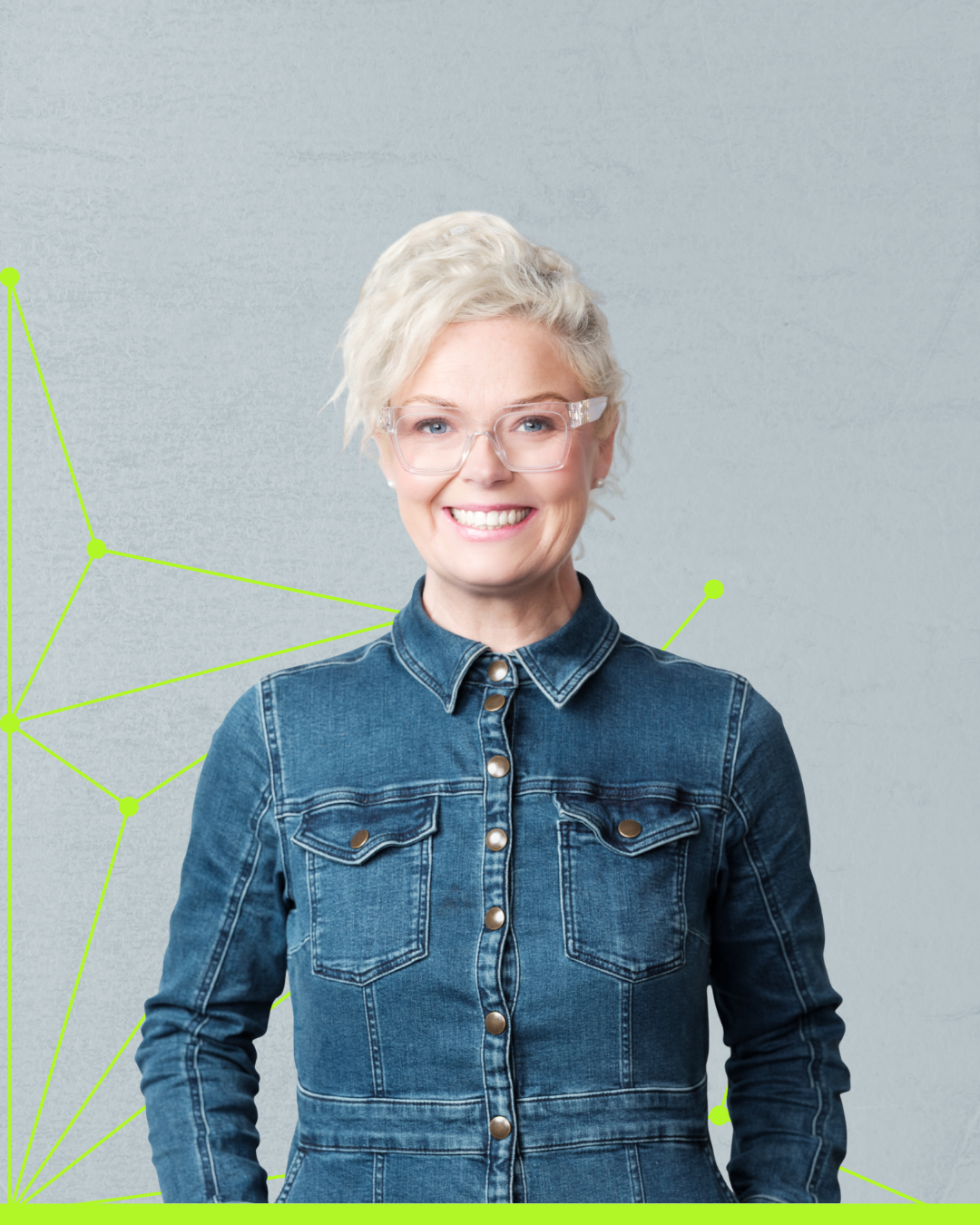 Smiling person in a denim shirt against a light gray background