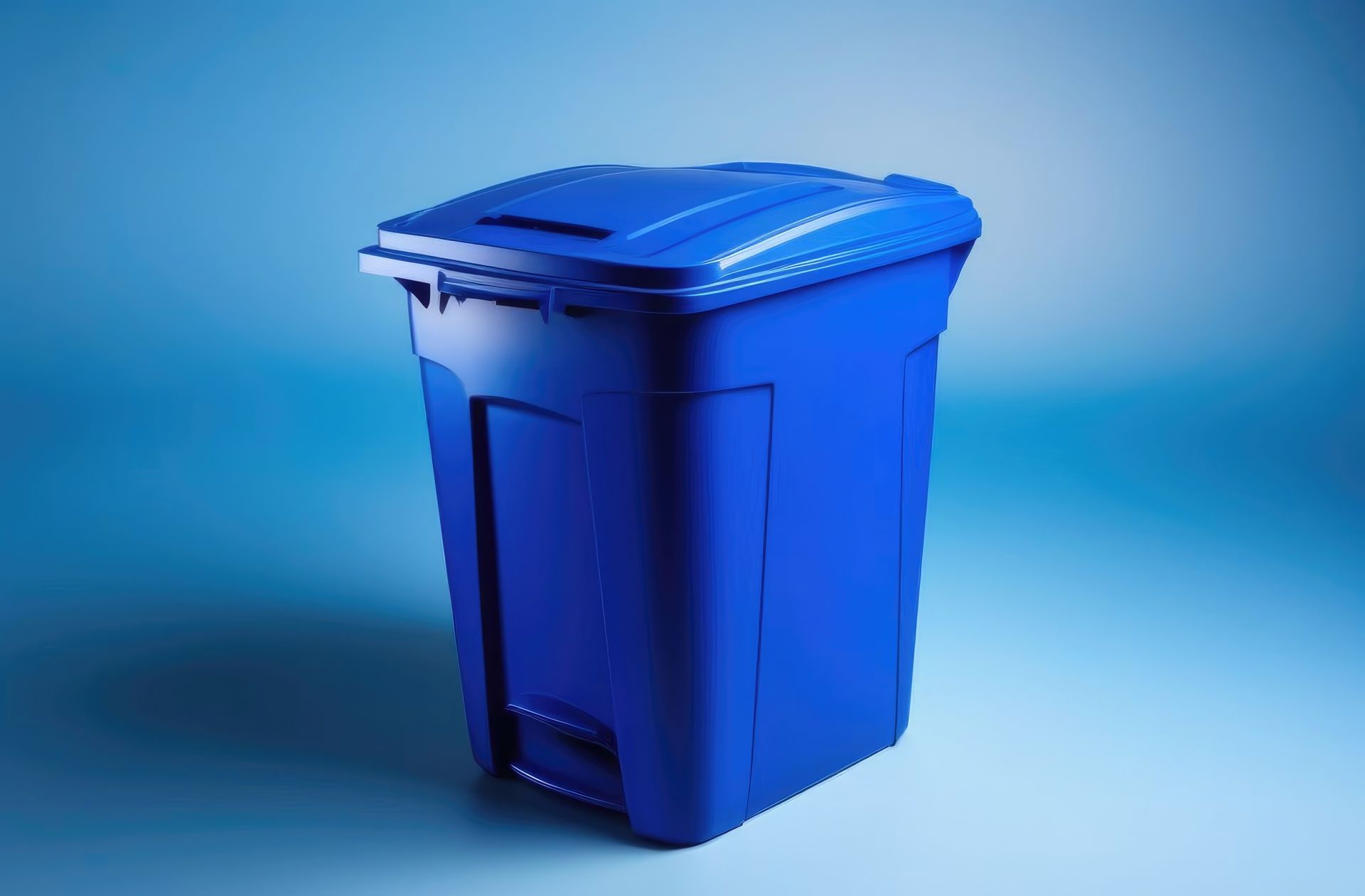 A blue trash can is sitting on a blue surface.
