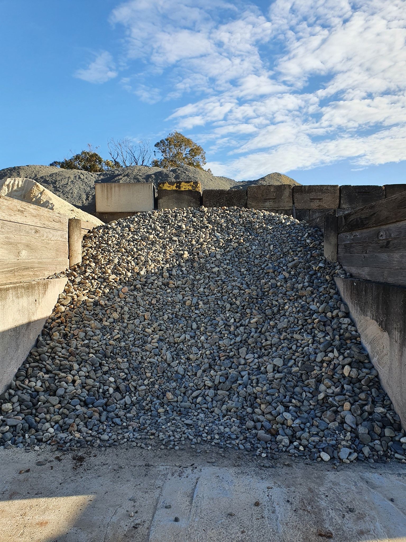 Pile of gray gravel in a concrete bin — Port Landscape Supplies in Port Macquarie, NSW