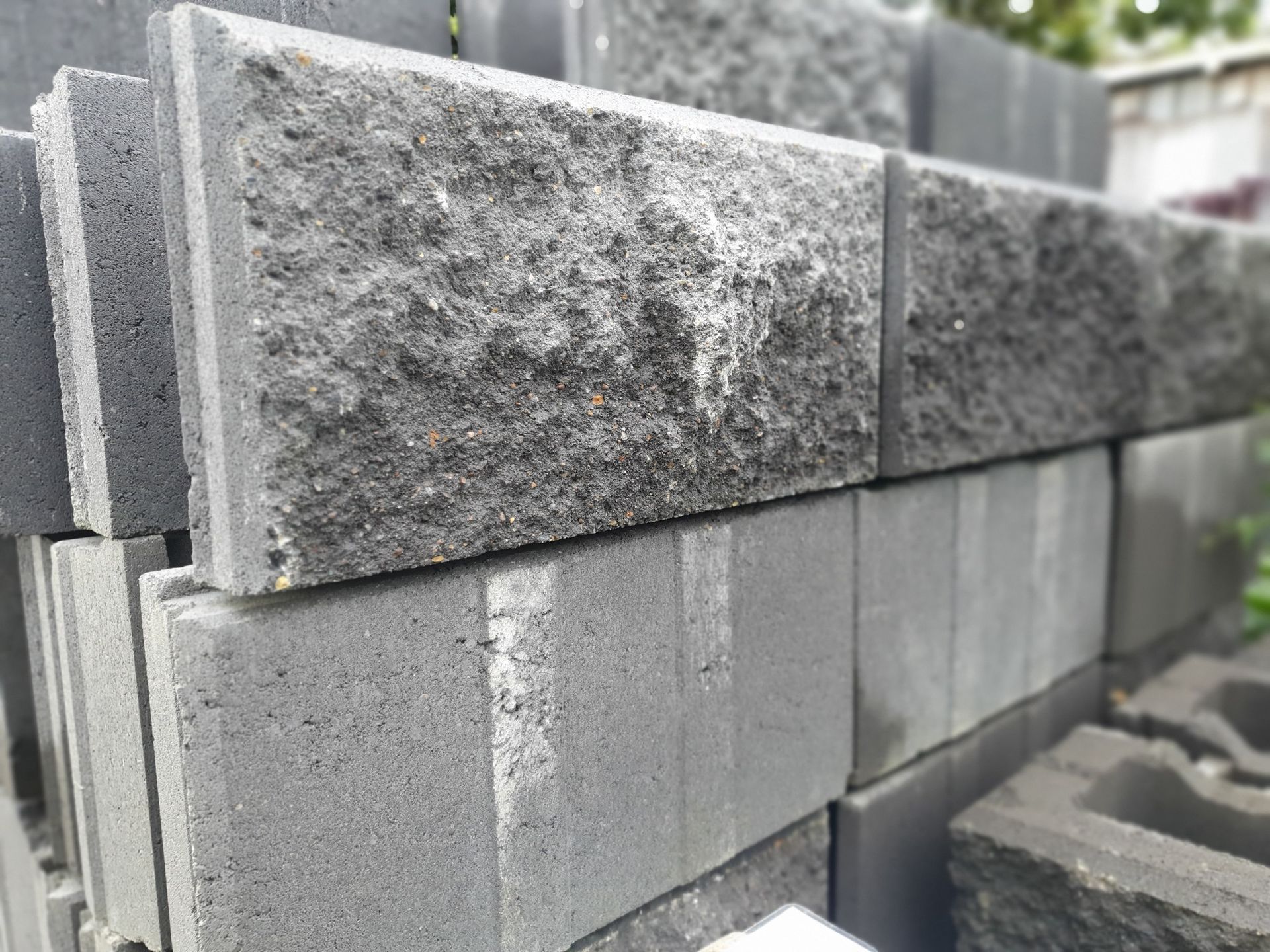 Pile Of Dark Grey Rectangular Concrete Blocks With Rough Textures Stacked — Port Landscape Supplies in Port Macquarie, NSW