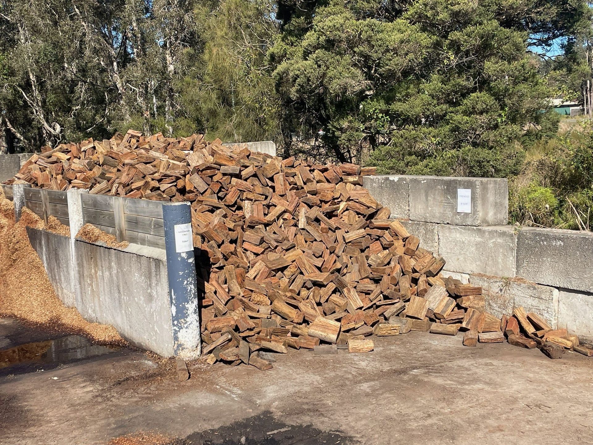 Pile of Brown Bricks Against Concrete Barriers in A Yard — Port Landscape Supplies in Port Macquarie, NSW