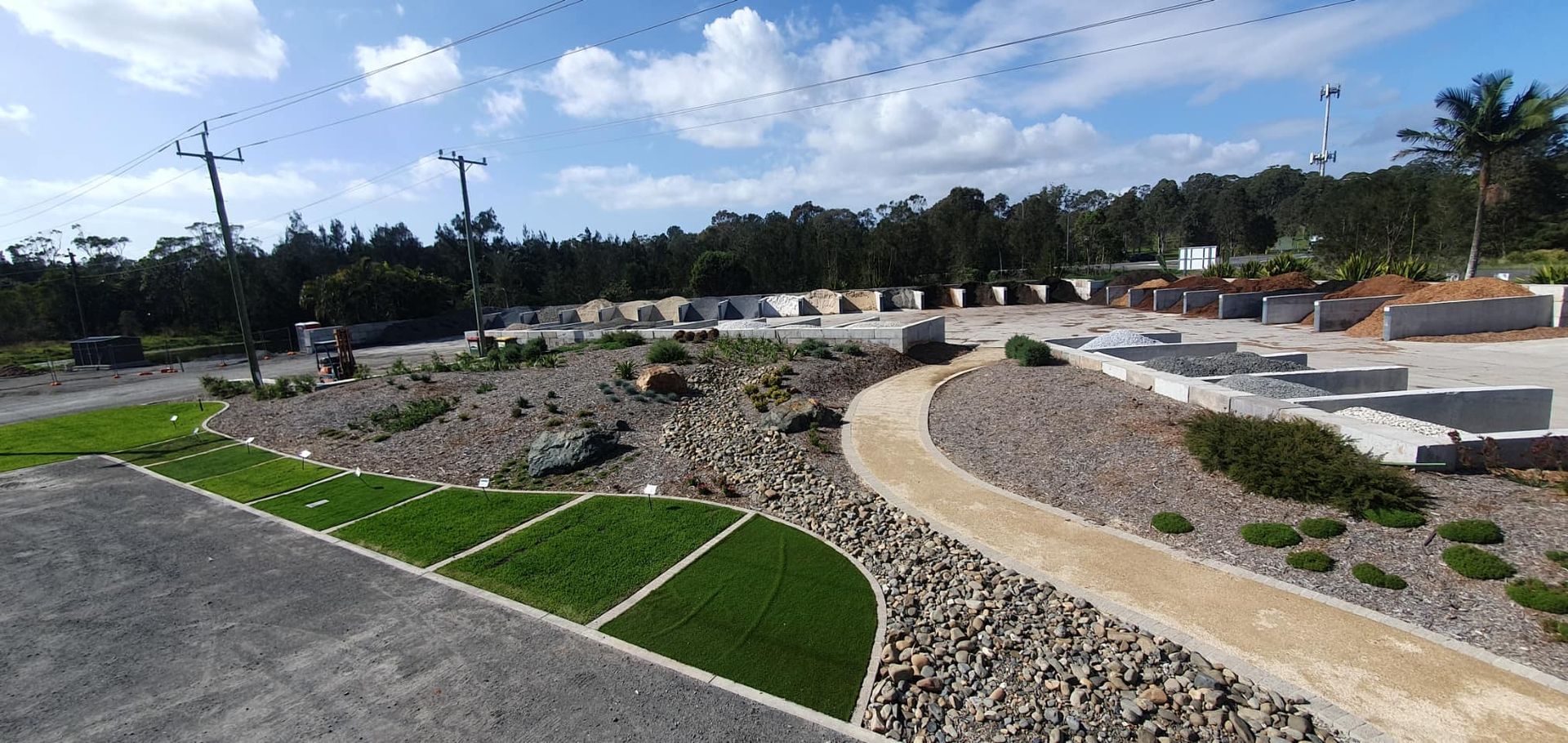 A Gravel Path With Green Grass Patches and Low Concrete Walls In A Landscaped Area — Port Landscape Supplies in Wauchope, NSW